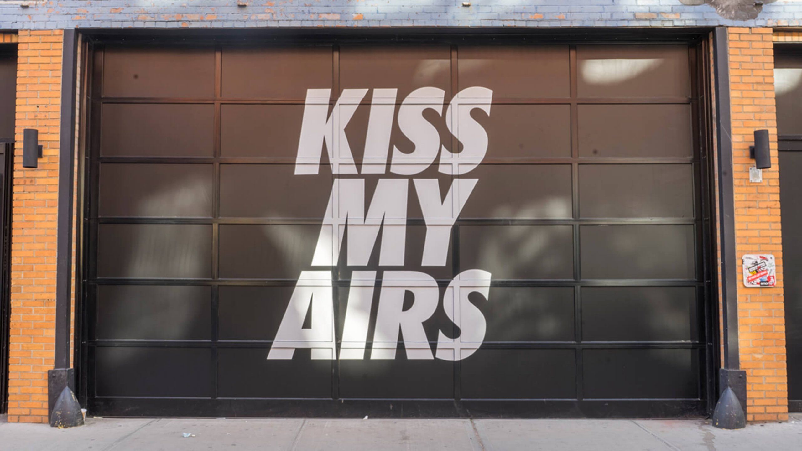 Industrial garage door with KISS MY AIRS displayed in bold letters