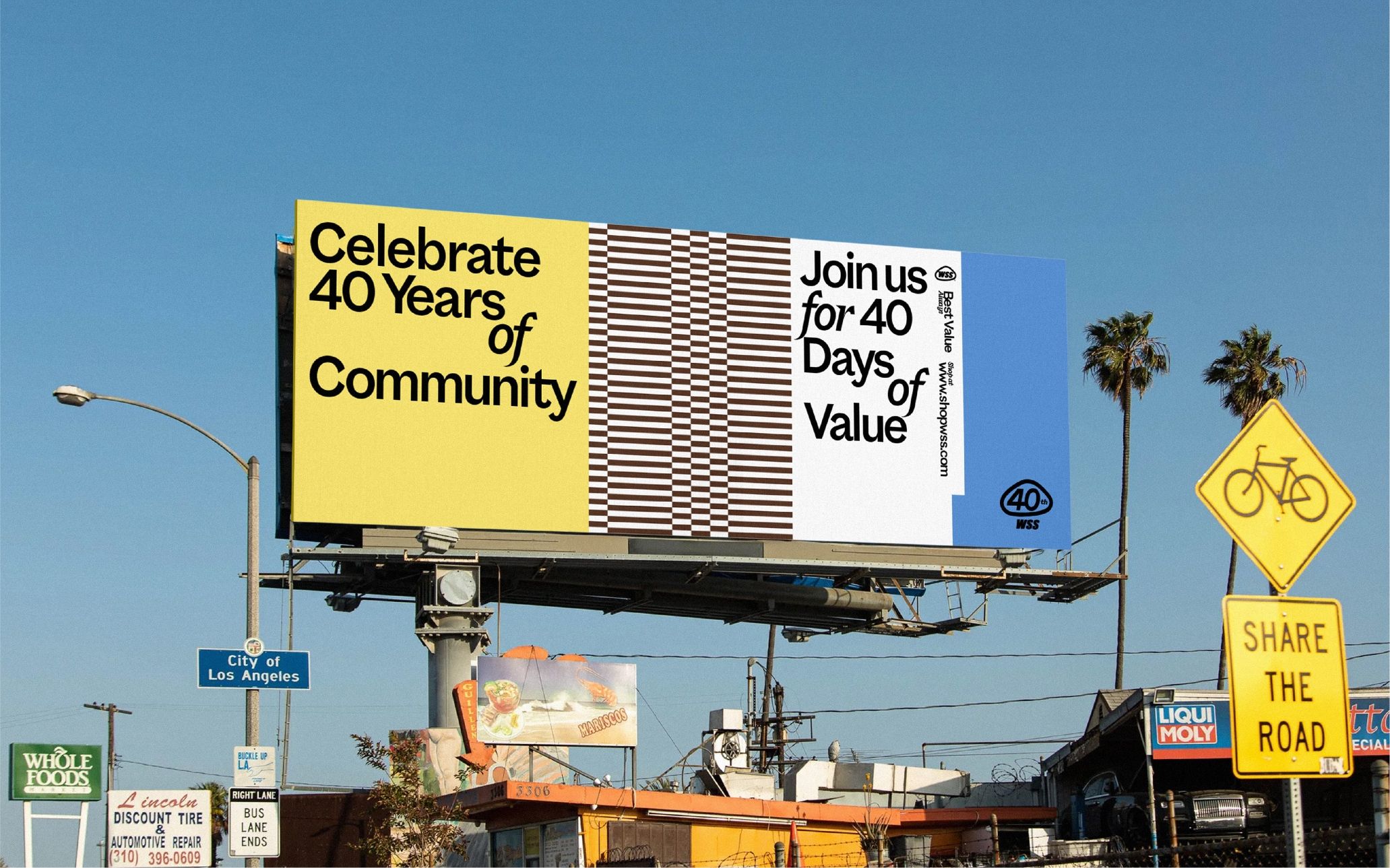 Billboard with the text "Celebrate 40 Years of Community" and "Join us for 40 Days of Value" against a multicolored background. It's located above a street in Los Angeles.