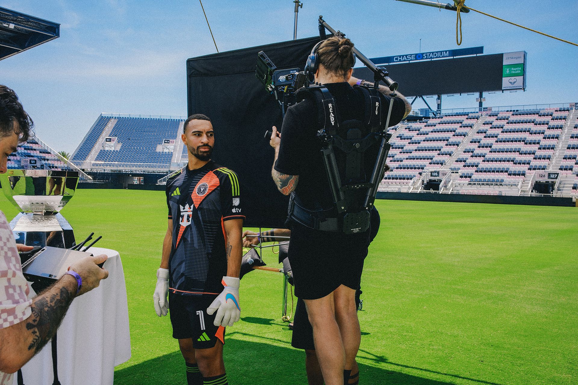 Soccer player poses infront of camera on empty stadium field