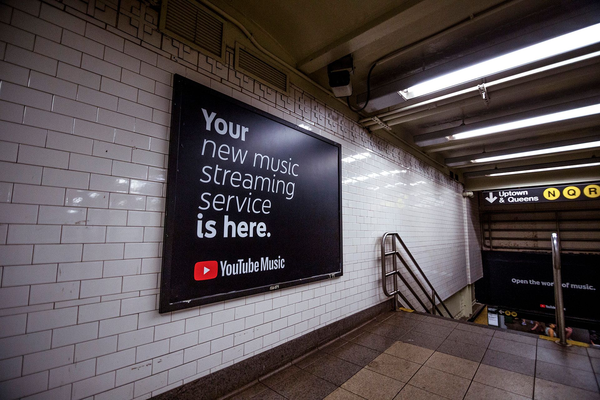 YouTube Music ad on tiled wall in Union Square train station at top of stairs. Your new music streaming service is here.