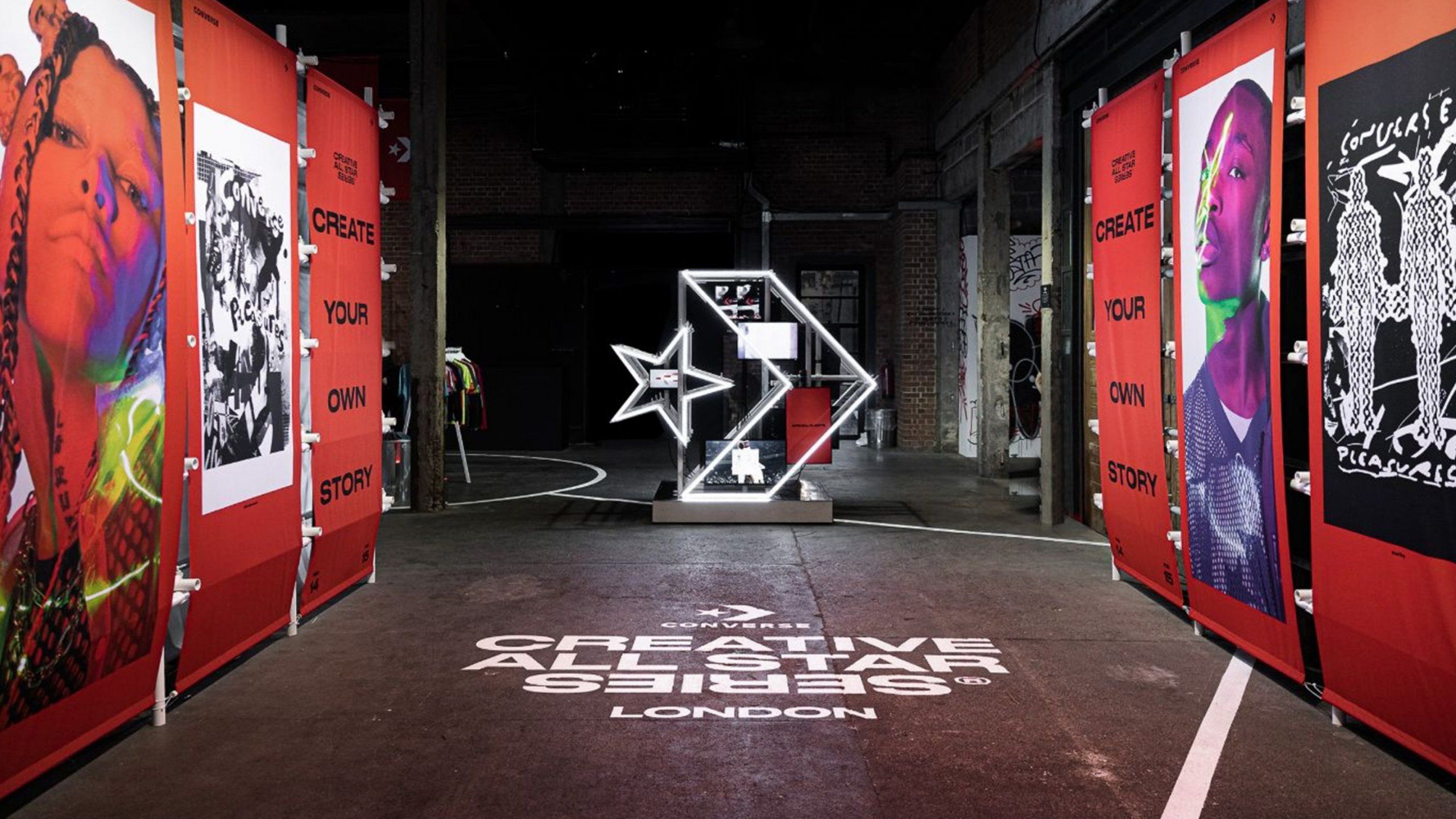 Converse Event space with Banners creating walls, Creative All Star Series London printed on floor and large Converse logo neon sign in middle of floor