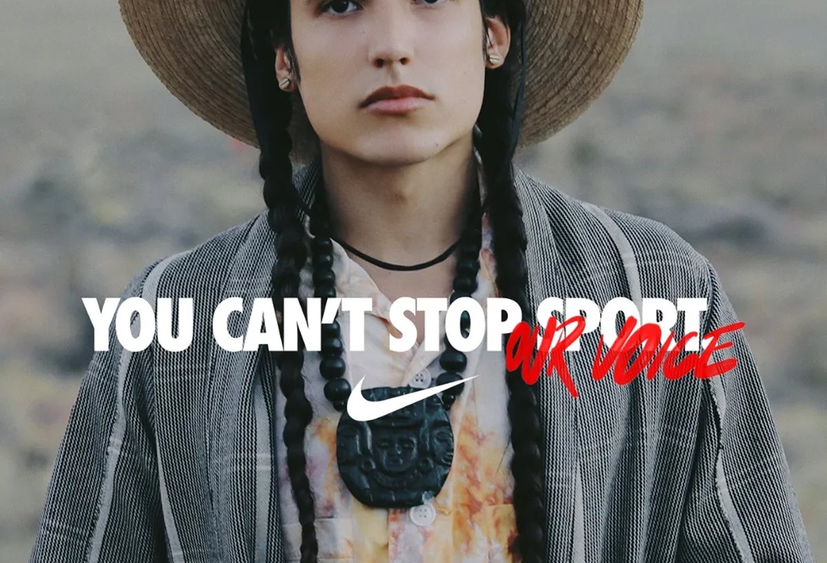A person with braided hair and a hat wears a patterned shirt and necklace, with the text "You can't stop our voice" and a Nike logo across the image.