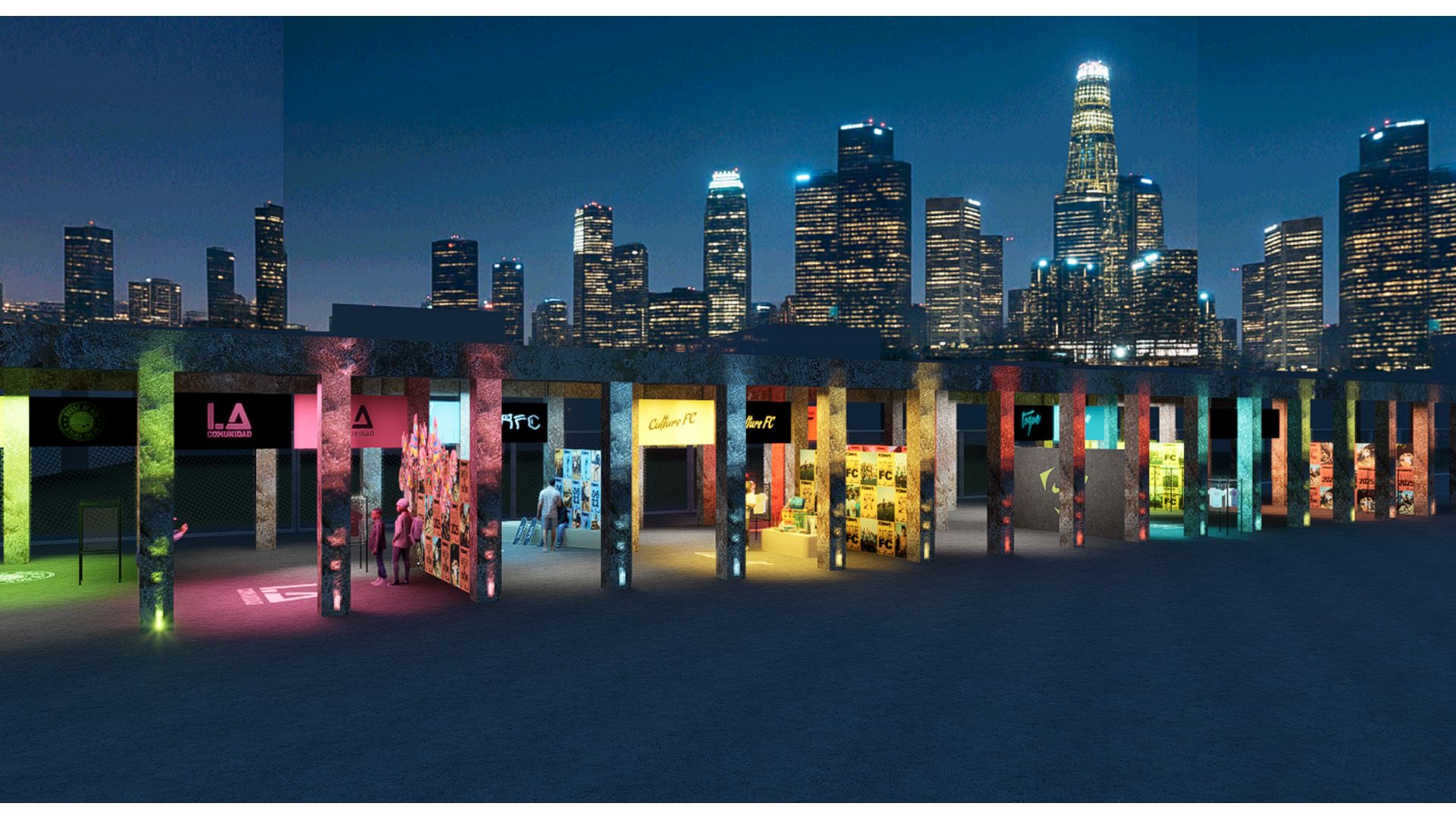 Row of colorful, illuminated booths set up outdoors at night with a city skyline featuring tall, lit skyscrapers in the background.
