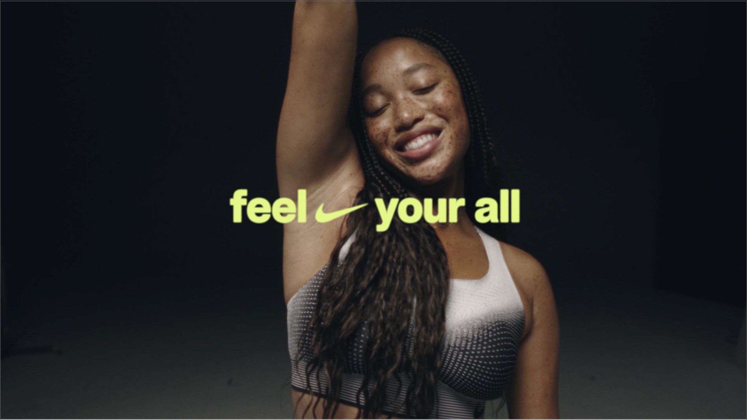 feel your all text with nike swoosh over women athlete smiling with arm raised.