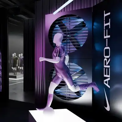 A display with a running mannequin in a sports outfit is shown near a large screen and a vertical "AERO-FIT" sign in a modern, dimly lit showroom.