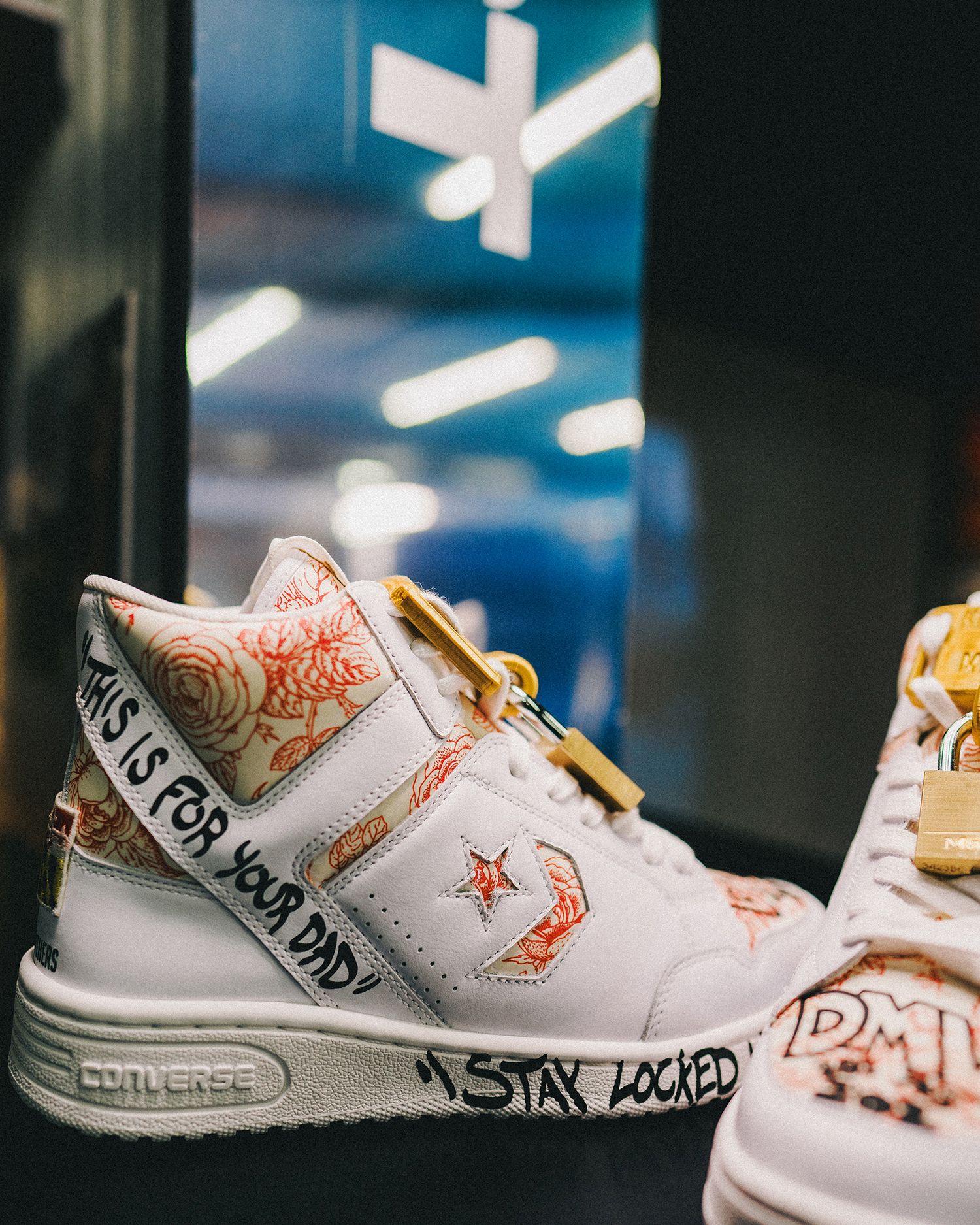 Lethal Shooter's custom Converse sneakers with floral patterns drawn into areas and marker written notes of This is for your Dad and Stay locked. Padlocks are on the laces