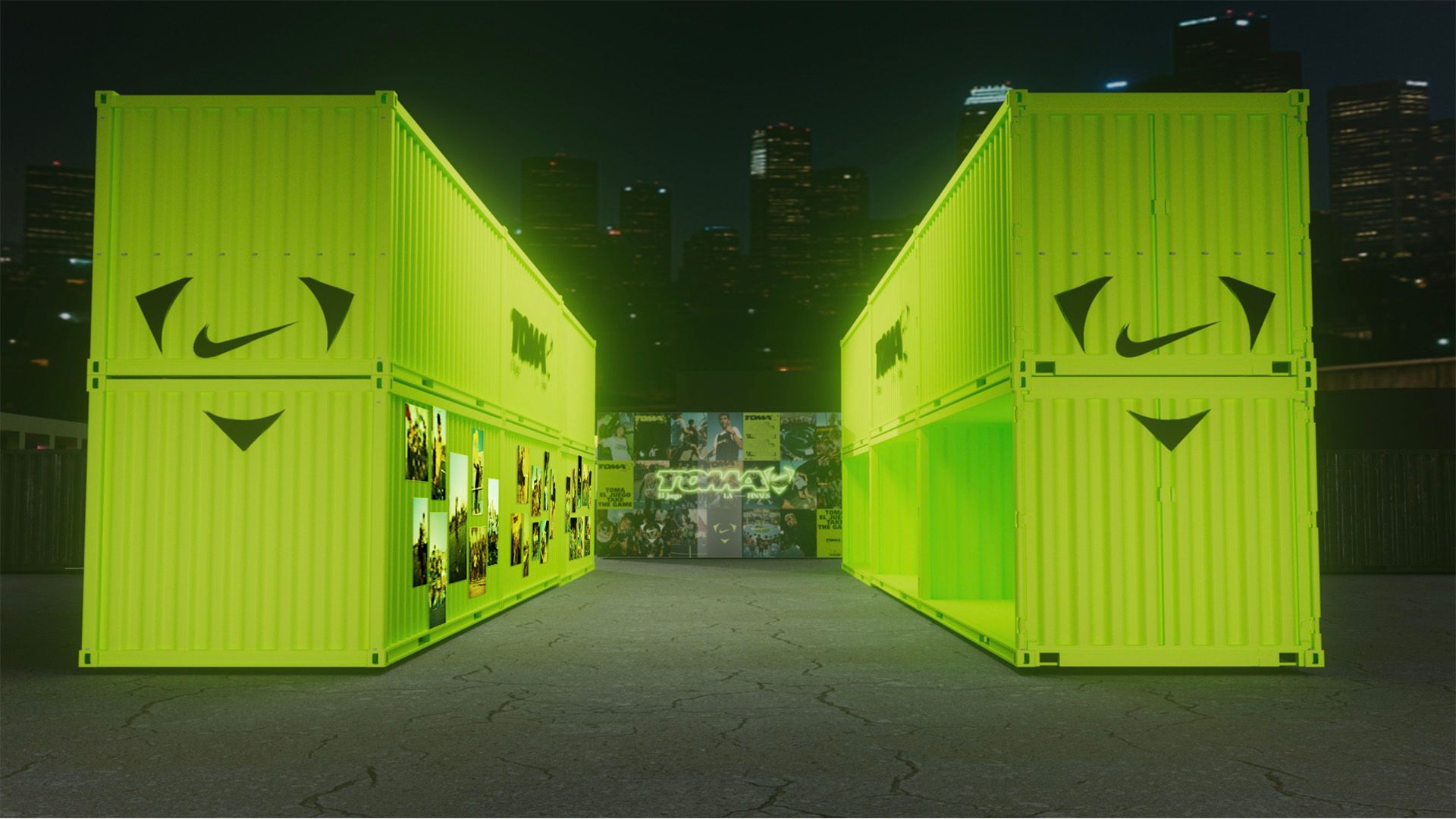 Two stacked neon green shipping containers with Nike logos are positioned outdoors at night, with city buildings in the background and a mural between them.