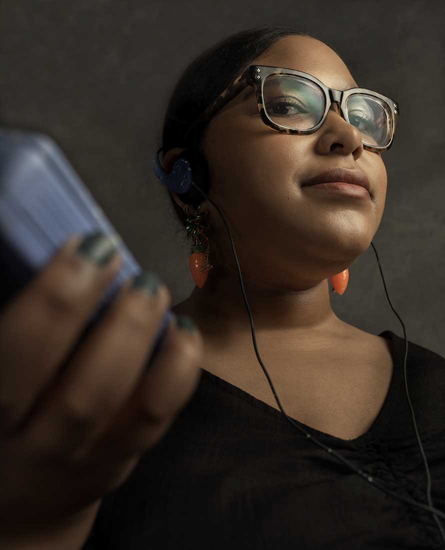 India Meyers holding music player and wearing headphones