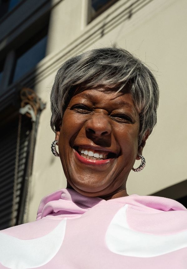 Close up woman smiling on street with pink Nike Fleece sweatshirt