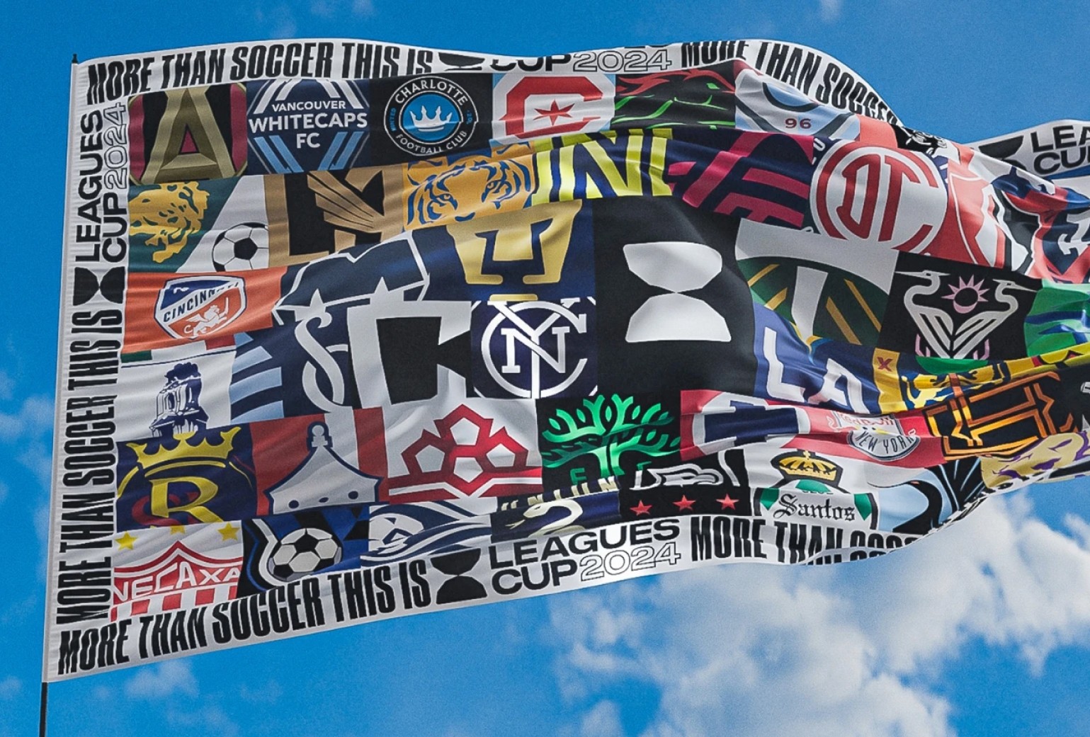 A flag featuring logos of various soccer teams from the Leagues Cup 2024 waves against a blue sky with clouds.