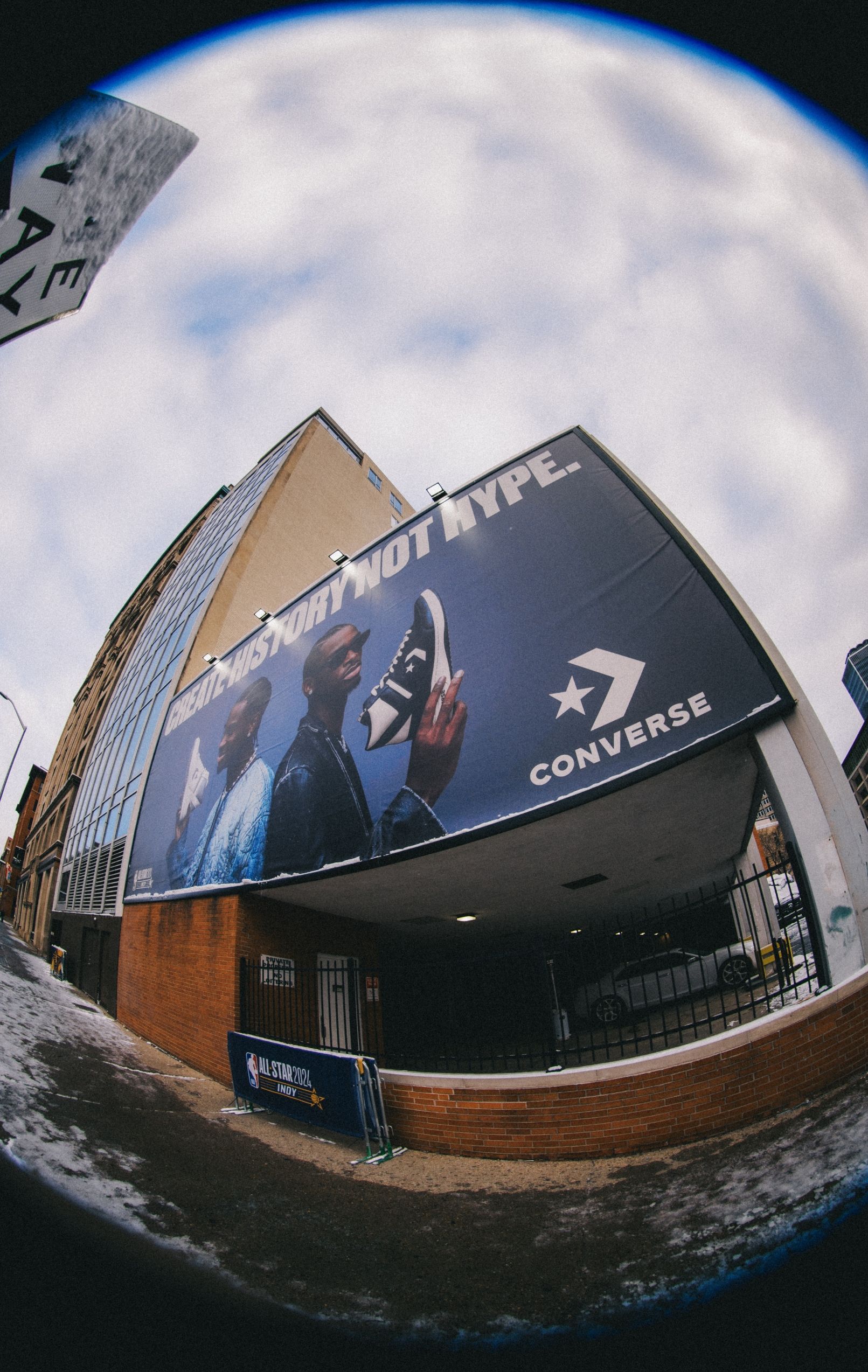 Billboard with 2 Shai Gilgeous-Alexander's back to back. One with white Converse sneaker, the other with black Converse sneaker. text on billboard reads Create History Not Hype