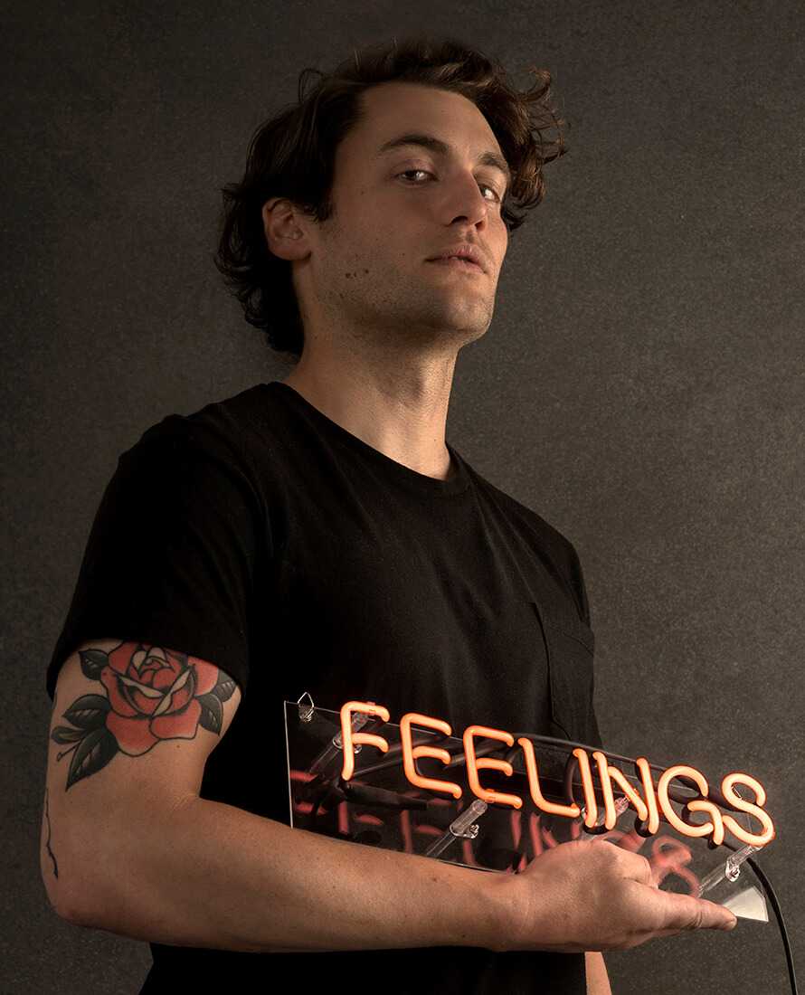 John Vieira holding neon feelings sign