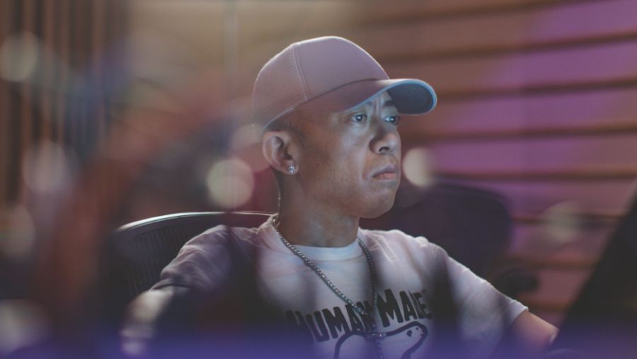 Close up of Nigo's face while he is at work on computer