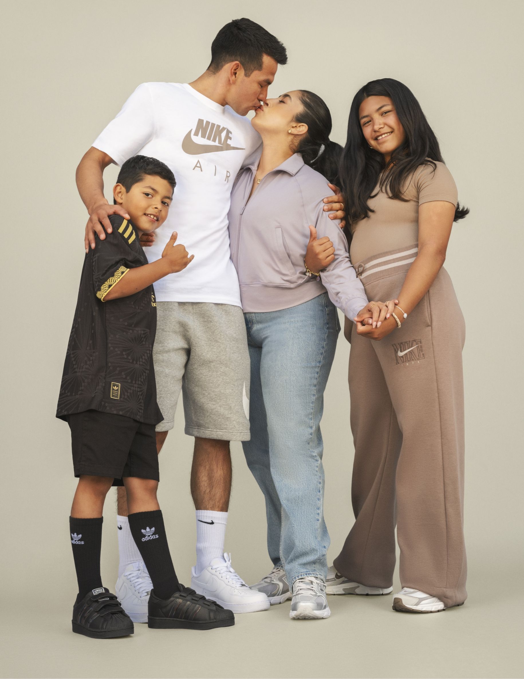 A man kissing a woman and two children.