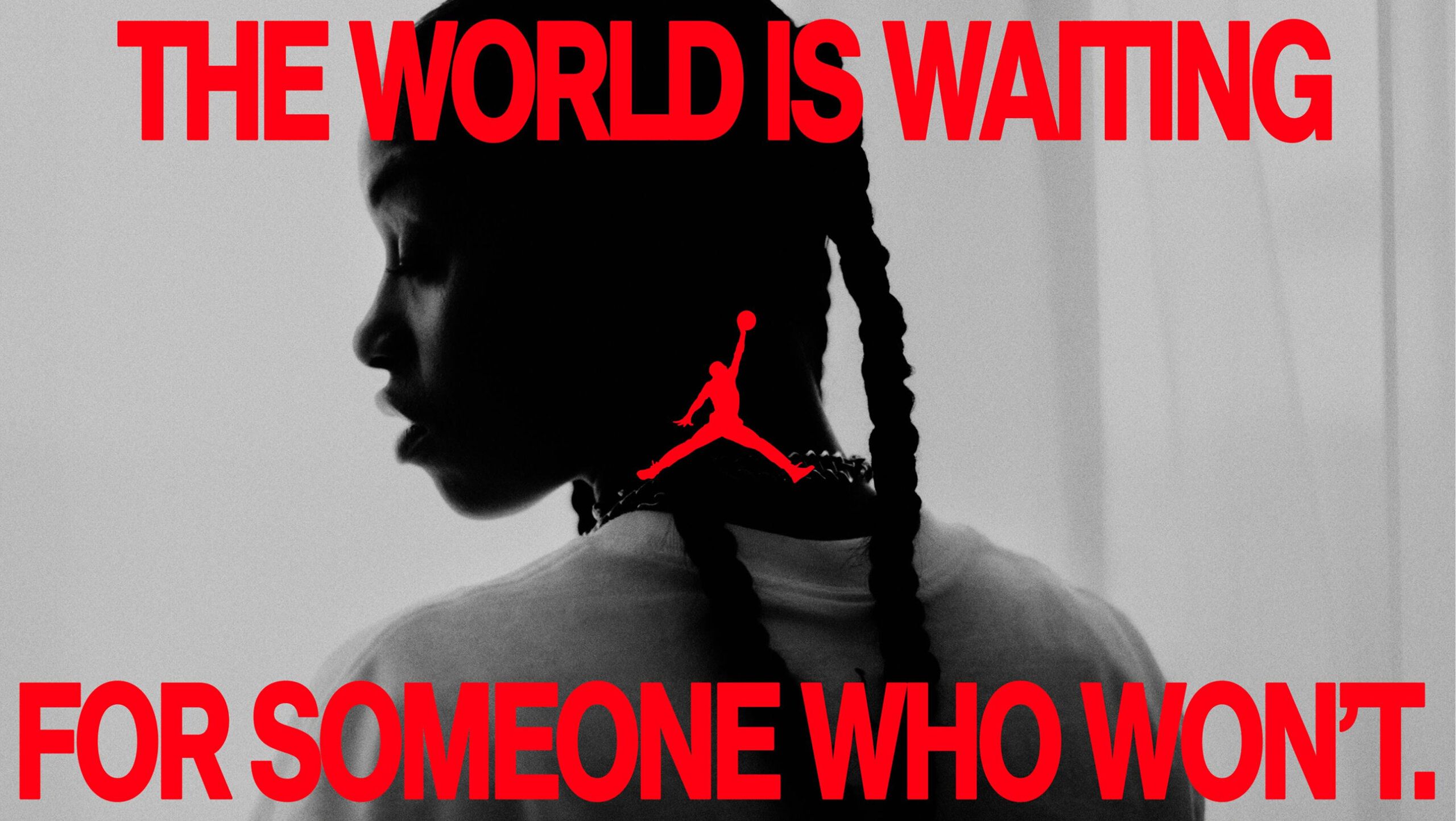 Black and white photo of a person with braids, facing sideways. Red text reads, "THE WORLD IS WAITING FOR SOMEONE WHO WON'T," with a Jumpman logo in the center.