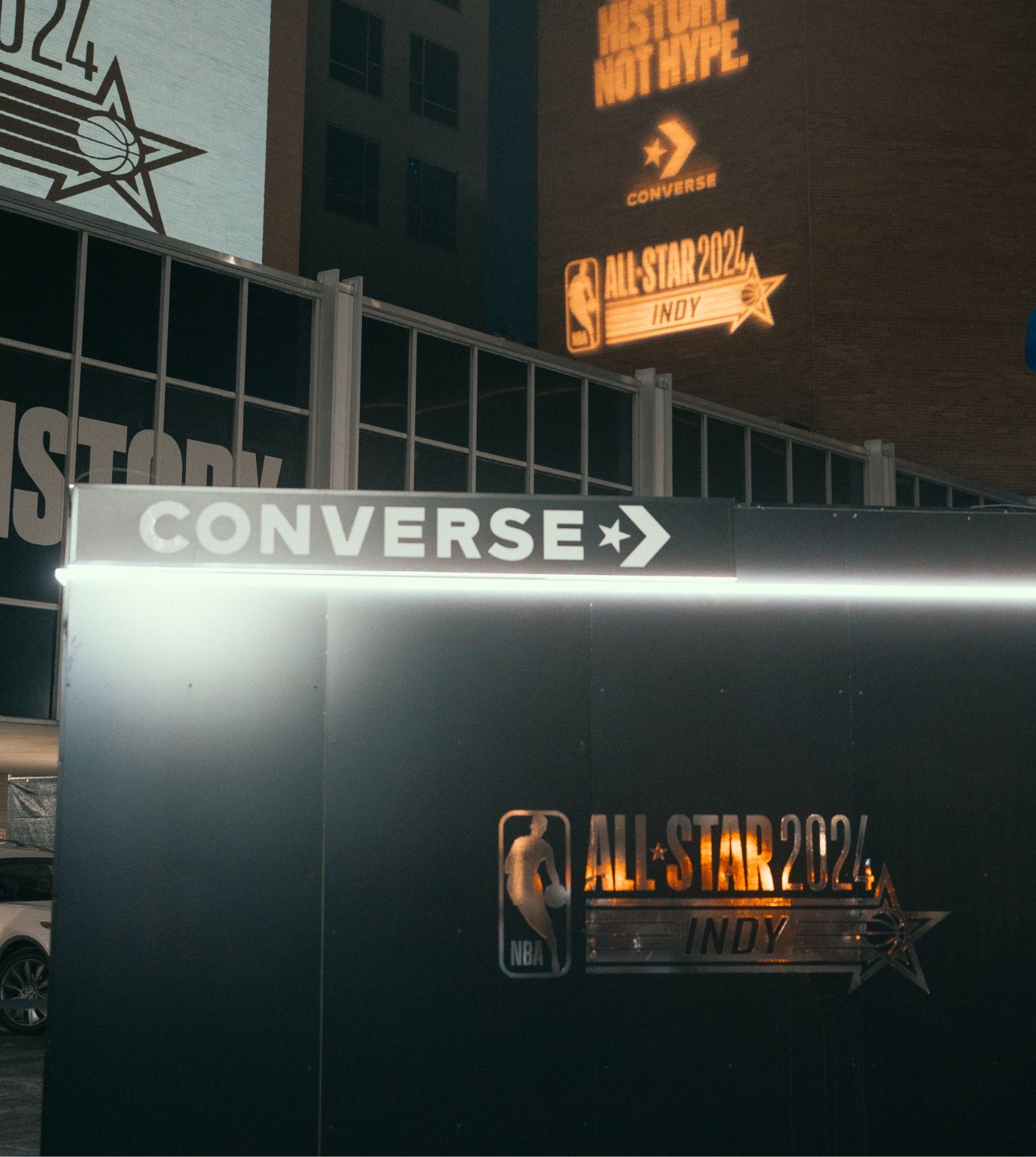 Night shot of black building with Converse logo and NBA 2024 All Star Indy mirrored logo