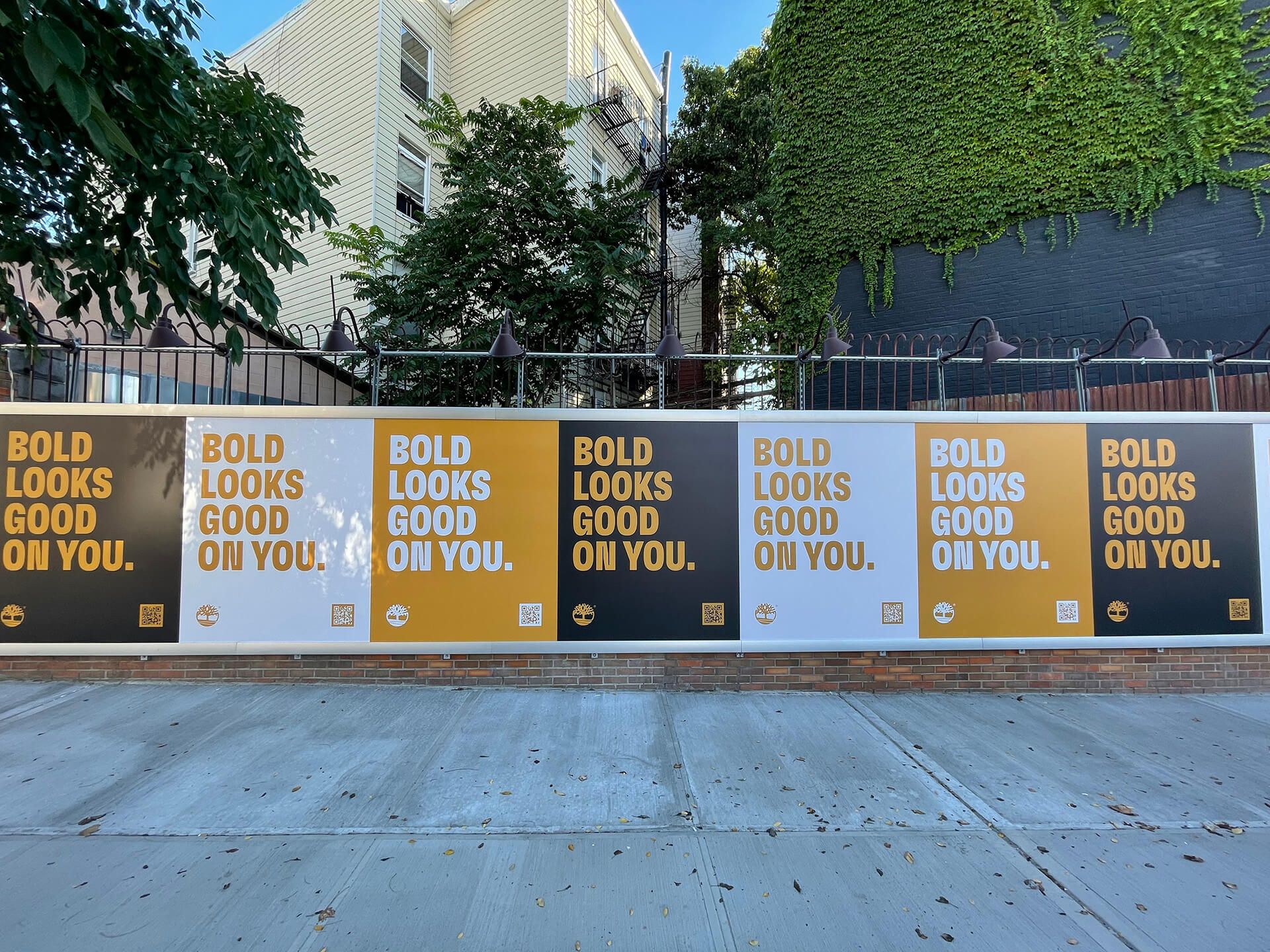 several Bold looks good on you signs lining sidewalk fence