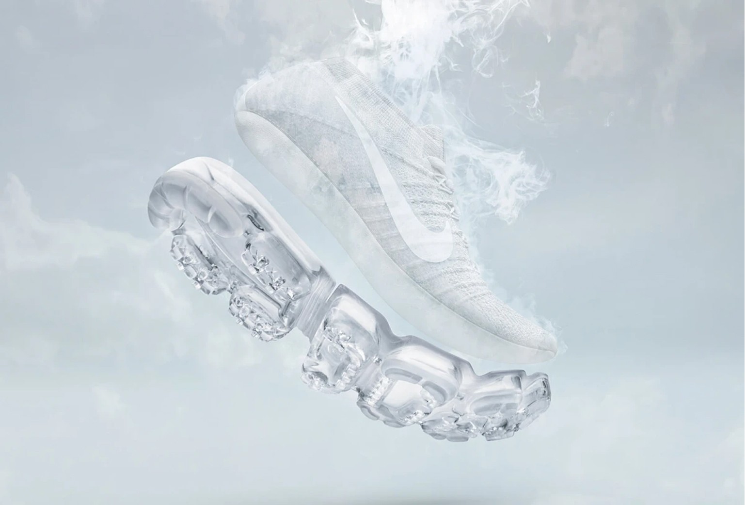 A white Nike sneaker with a translucent sole appears to float in mid-air, surrounded by wisps of smoke against a pale, cloudy background.