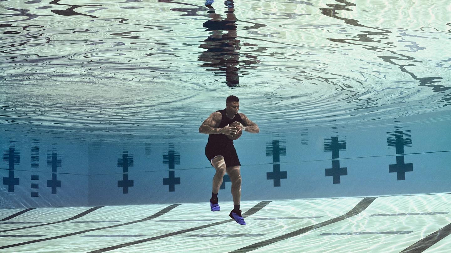 Zion holding basketball underwater in pool
