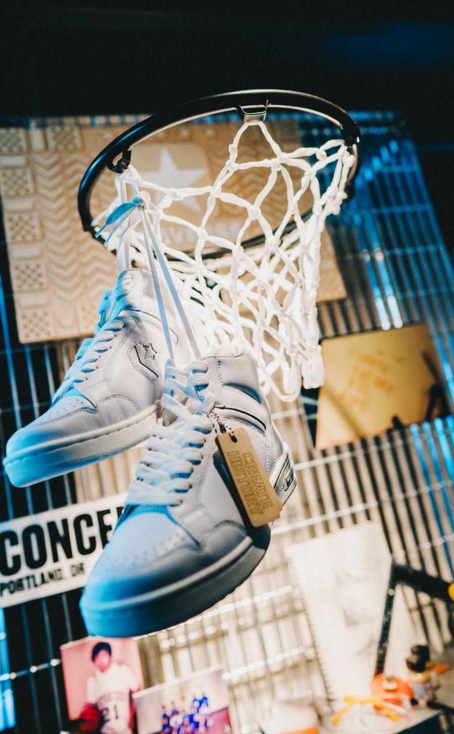 converse sneakeers hanging from basketball hoop net