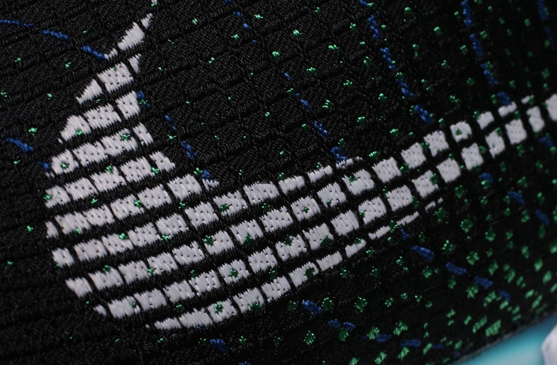 close up Nike swoosh logo woven into side of shoe