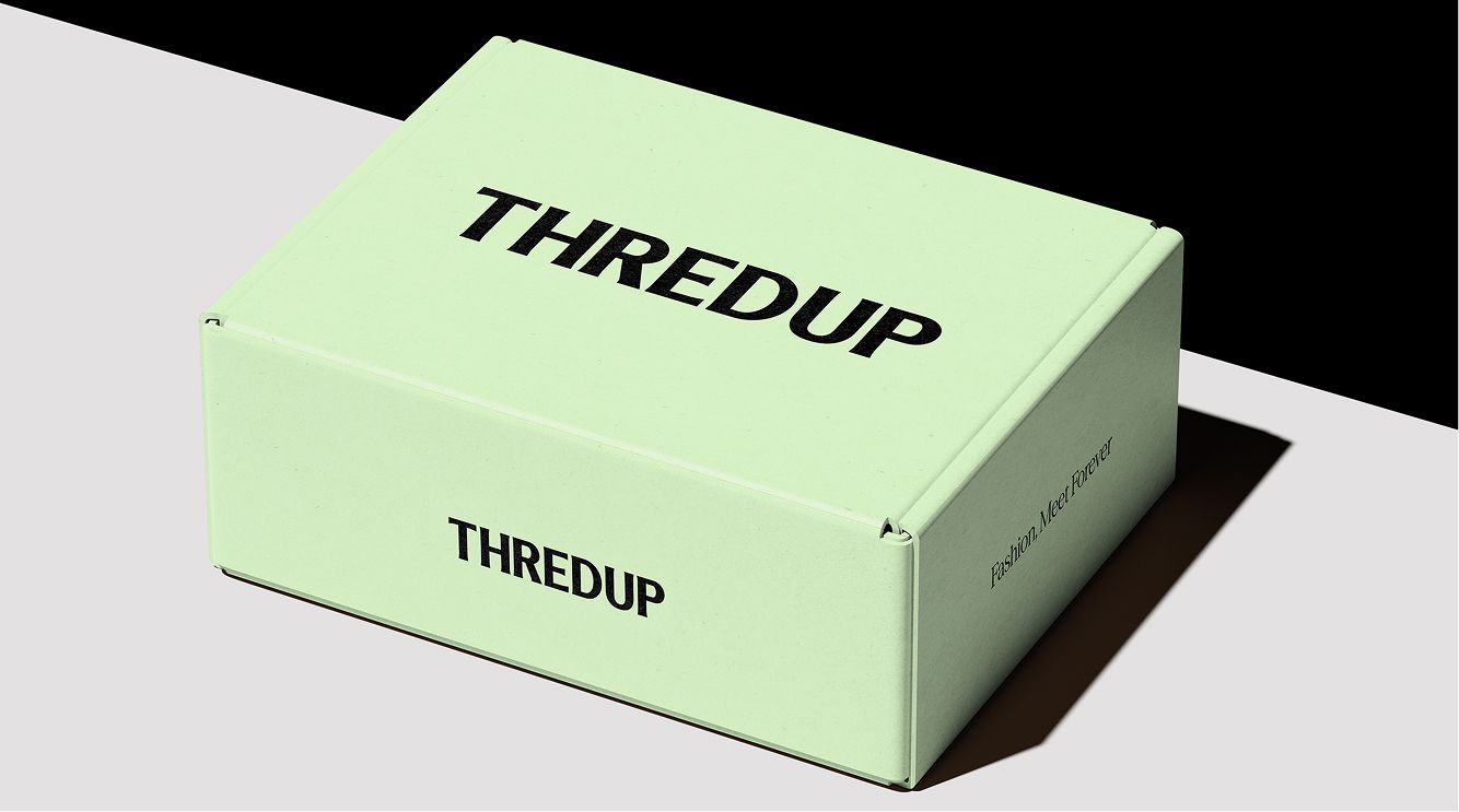 A light green box with "THREDUP" printed in bold black letters on the top and side, placed on a two-tone background of light gray and black.