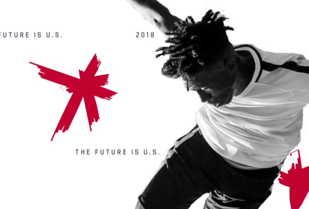 A soccer player in a white jersey and dark shorts is mid-action against a white background with red graphic elements and text reading "THE FUTURE IS U.S." and "2018.