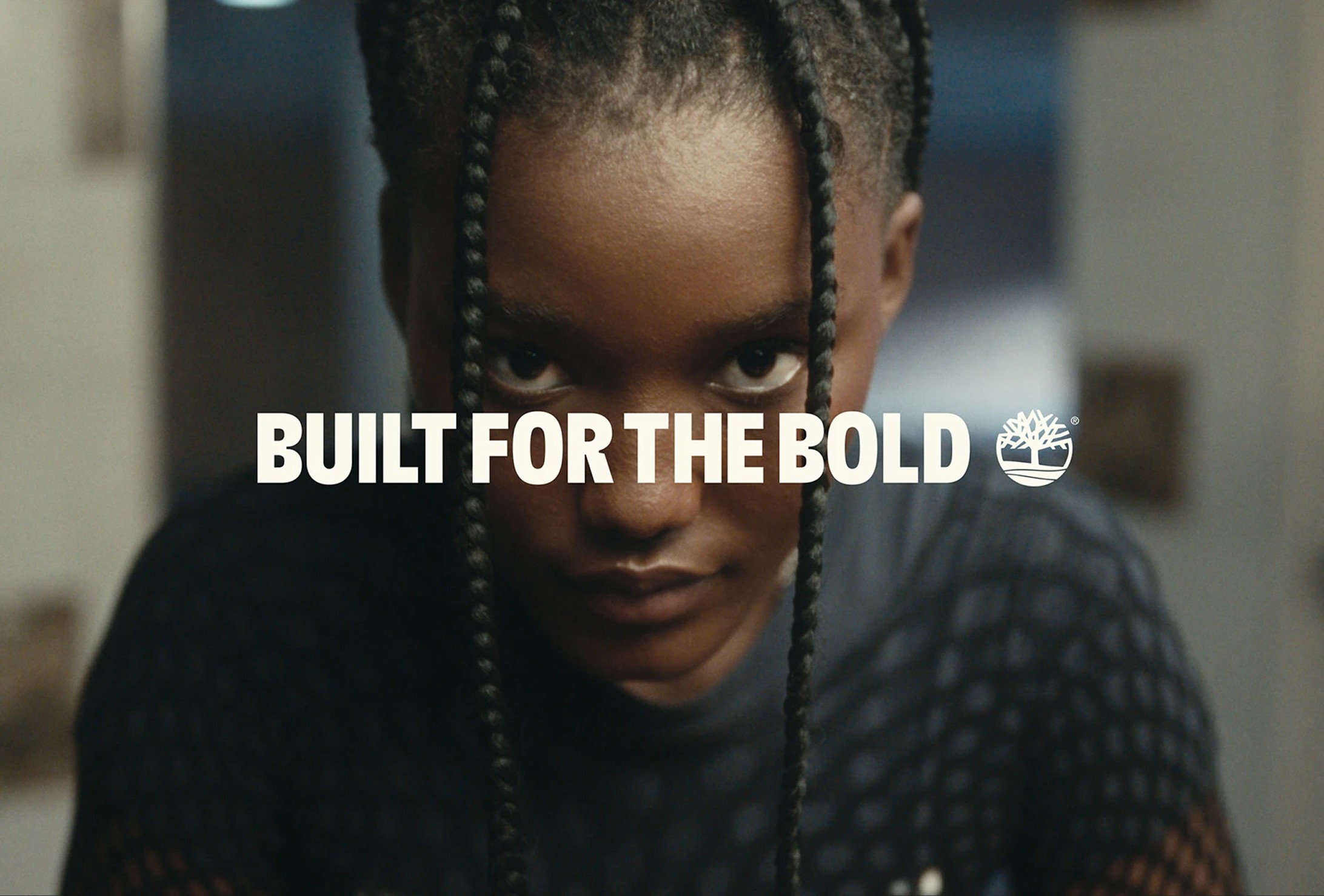 A person with braided hair looks forward intently; the text "BUILT FOR THE BOLD" and a Timberland logo are centered over the image.