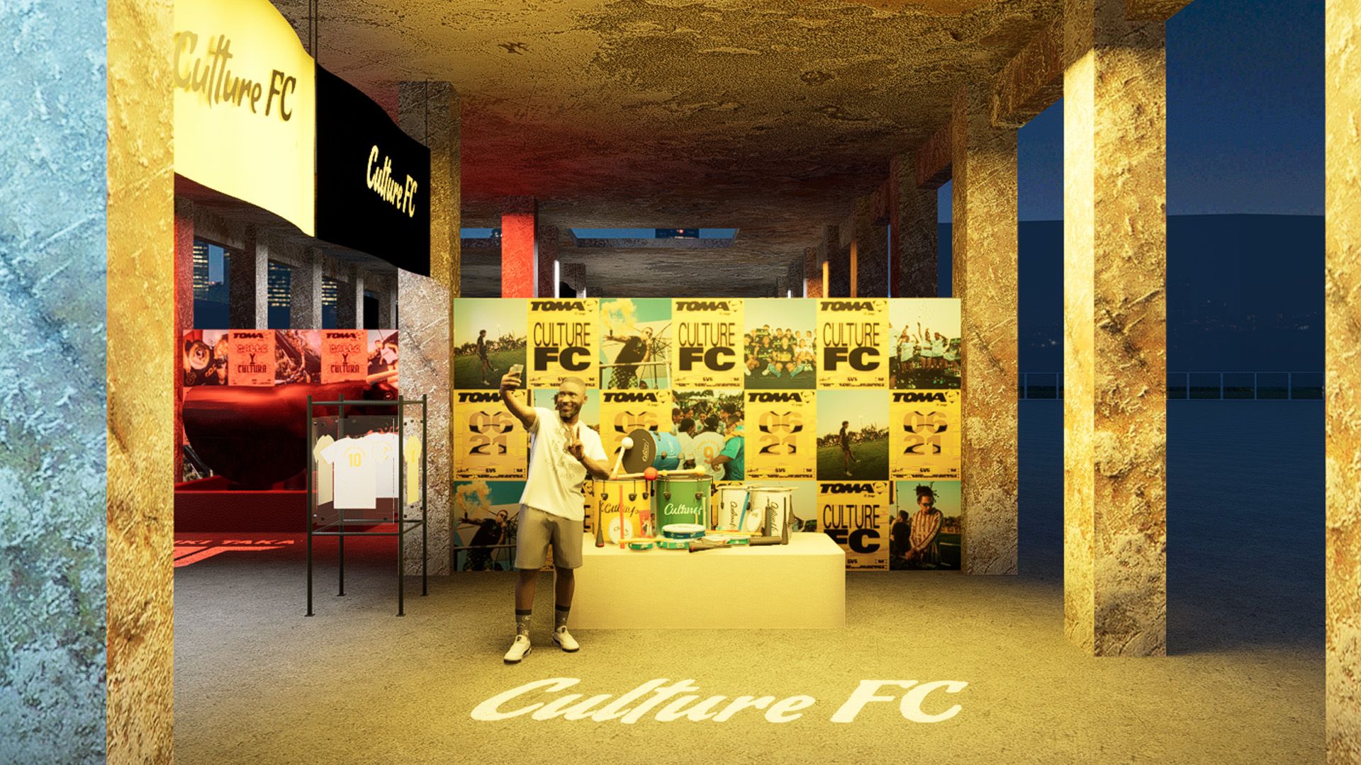 A man stands in front of a Culture FC merchandise booth with posters, apparel, and soccer-themed items on display in a concrete pavilion.