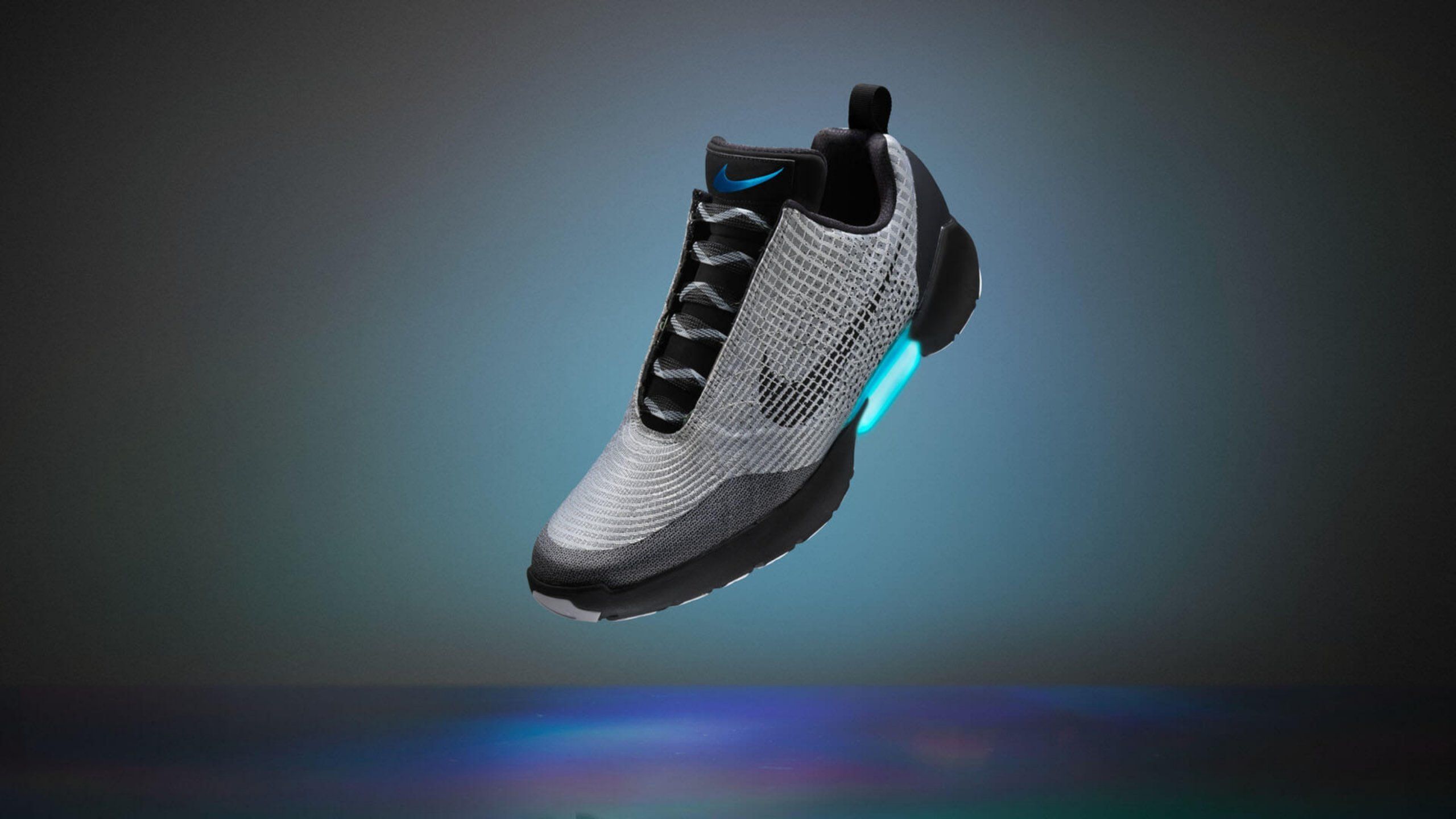 Nike Hyper Adapt in gray colorway suspended in air with light up arch