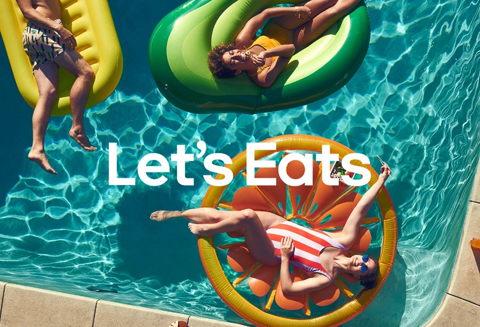 Three people on pool floats in a swimming pool, seen from above; the text "Let's Eats" is overlaid on the image.